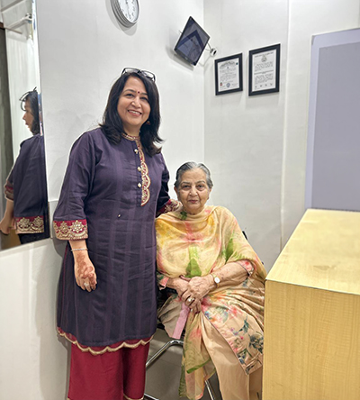 Two women at Muskan Speech & Hearing Centre, one standing beside the other seated